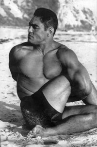 Rickson Gracie doing a Yoga twist on the beach