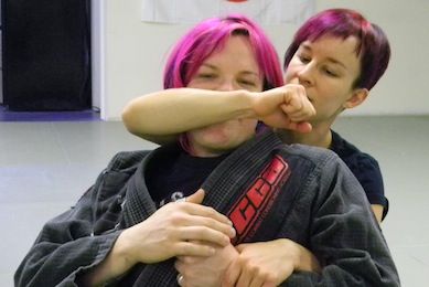 Female grappler showing how to attack from rear mount
